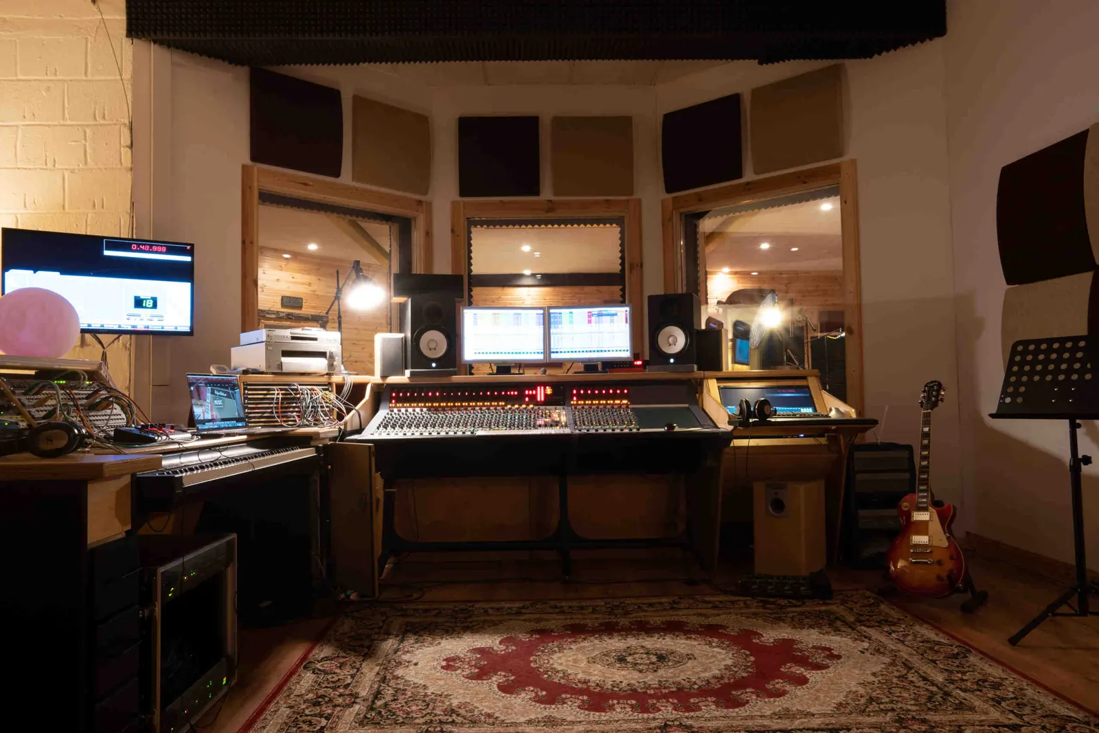 Regieraum von Audio Cavern mit der AMS-Neve-Konsole, Teppichen und warmem Licht